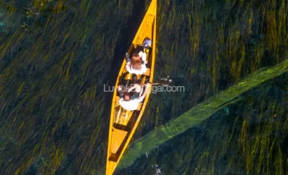 Sepasang kekasih dengan perahu di Danau dengan air jernih sampai terlihat tumbuhan bawah air