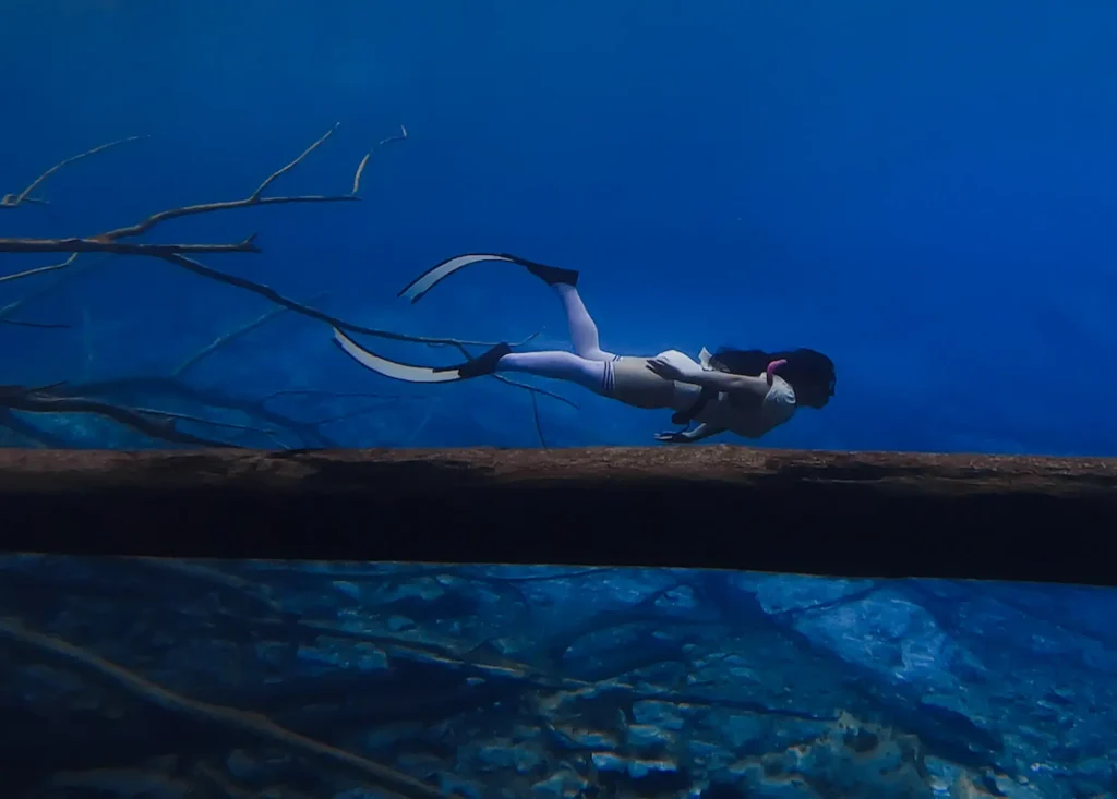 Snorkeler exploring crystal clear Paisu Pok Lake with underwater visibility of 10-15 meters in Banggai Islands Sulawesi Indonesia