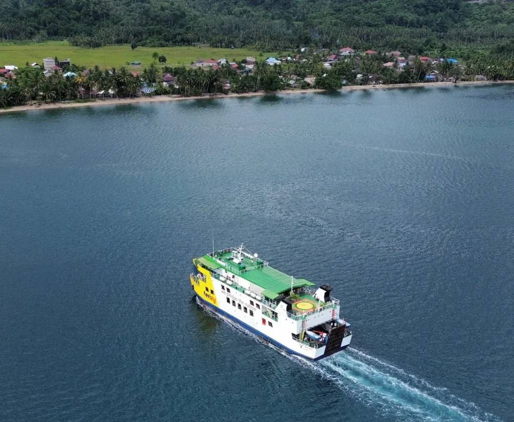 Ferry de passagers arrivant à Poisson des Îles de port à l'île de silhouettes au loin