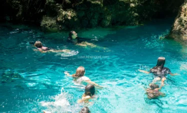 Beberapa orang berenang di air jernih berwarna biru toska