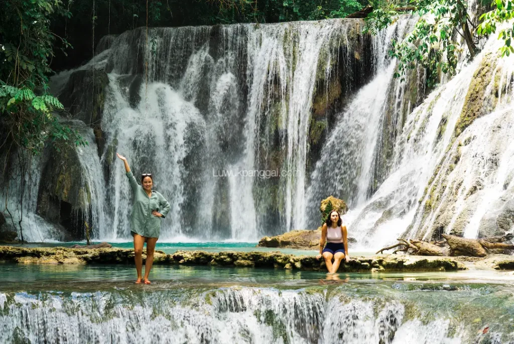 Dua orang wanita menikmati keindahan air terjun