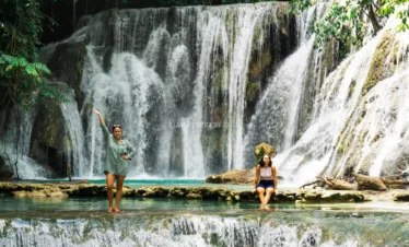 Dua orang wanita menikmati keindahan air terjun