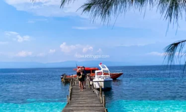 Pelabuhan kayu pantai puganda dengan air biru toska