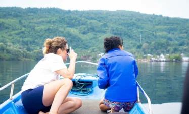 Dua orang turis menikmati keibndahan perjalanan laut