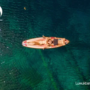 Una coppia sdraiata su un SUP in mezzo al lago Paisu Pok
