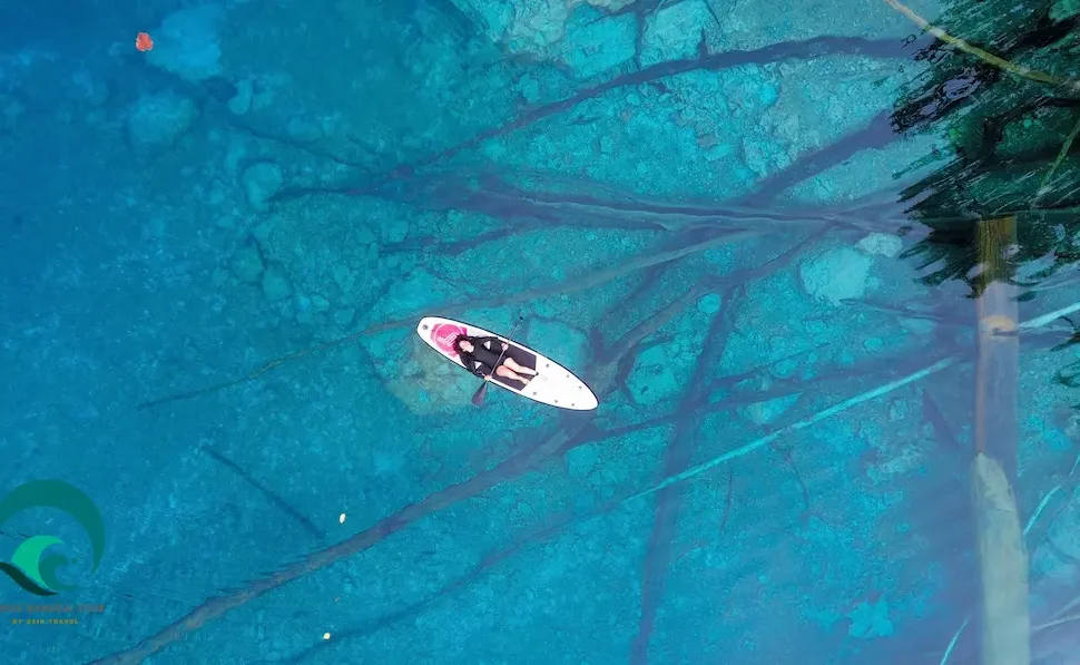 Woman relaxing on a paddle board in clear blue Paisupok lake