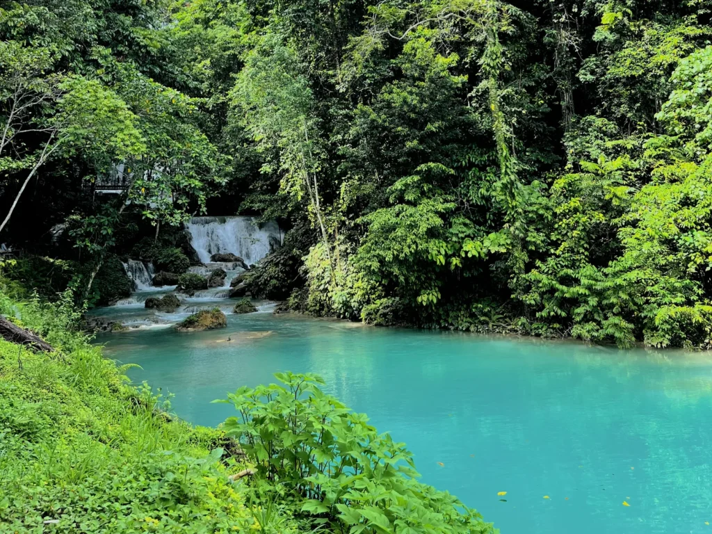 Kolam biru Air Terjun Piala di tengah hutan dekat Luwuk
