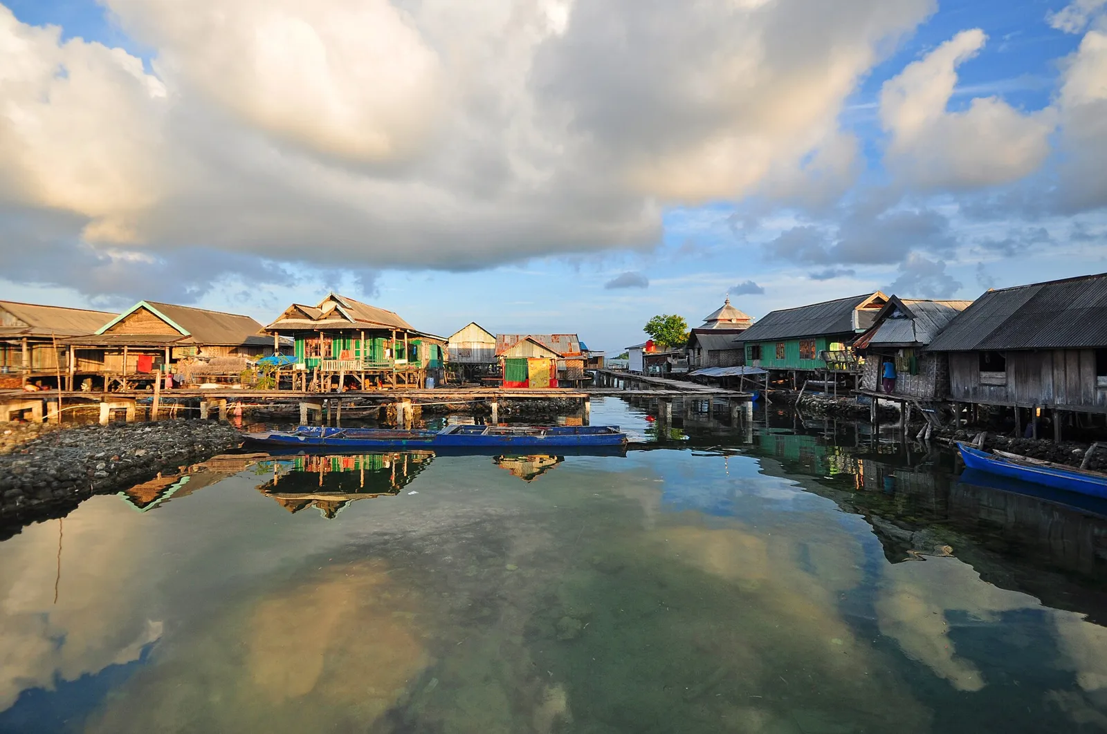 Bajo stilt houses reflected in calm water at Sampela village, Wakatobi
