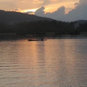 Lelaki Bajo mendayung sampan kayu saat senja di Jaya Bakti, Pagimana, dekat Luwuk