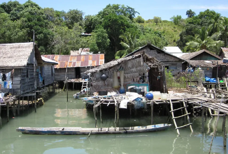 Palafitte bajau e una canoa scavata nel tronco nel villaggio di Bokori, Sulawesi