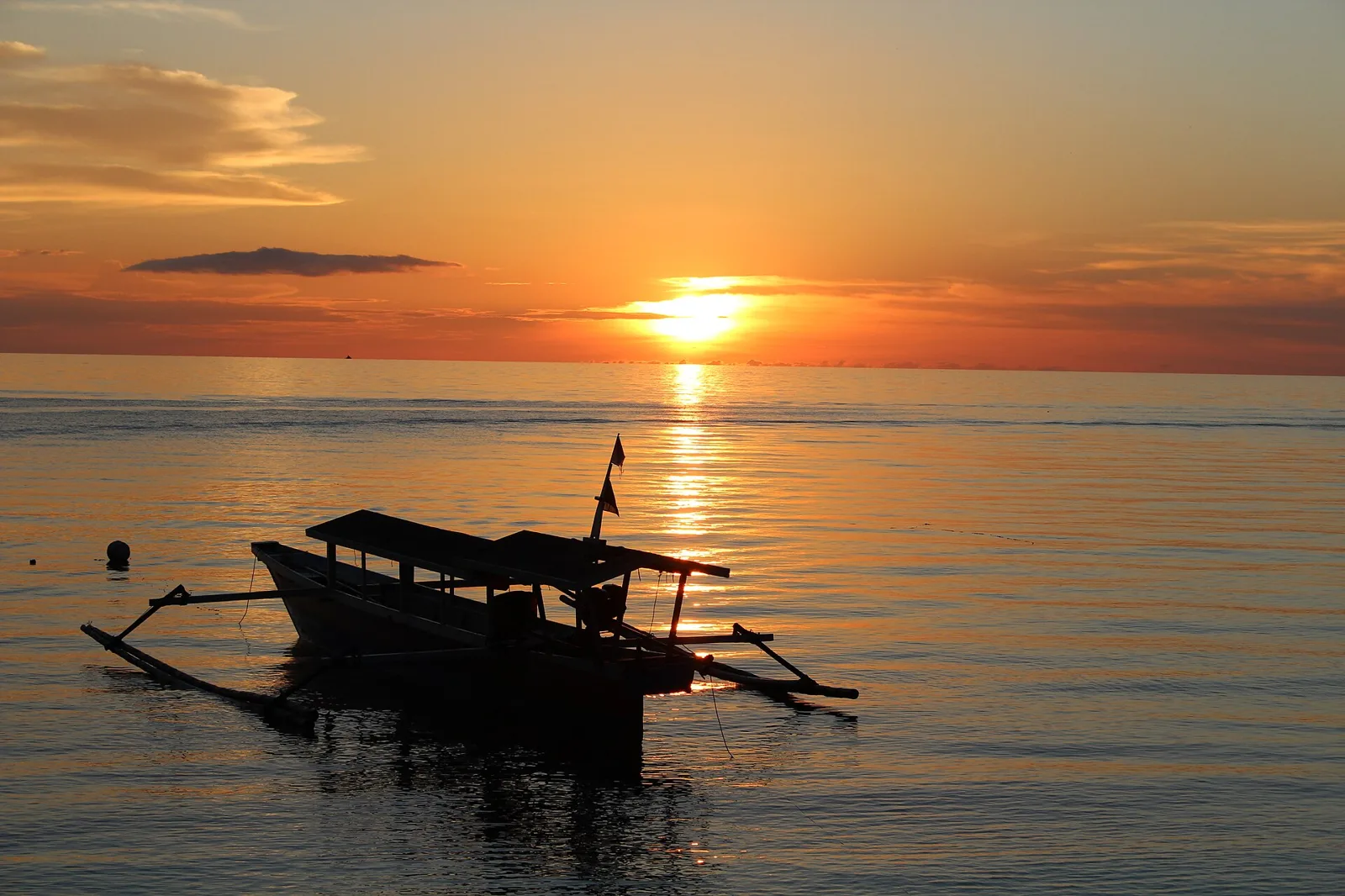 Auslegerboot im Gegenlicht des Sonnenuntergangs auf den Togian-Inseln
