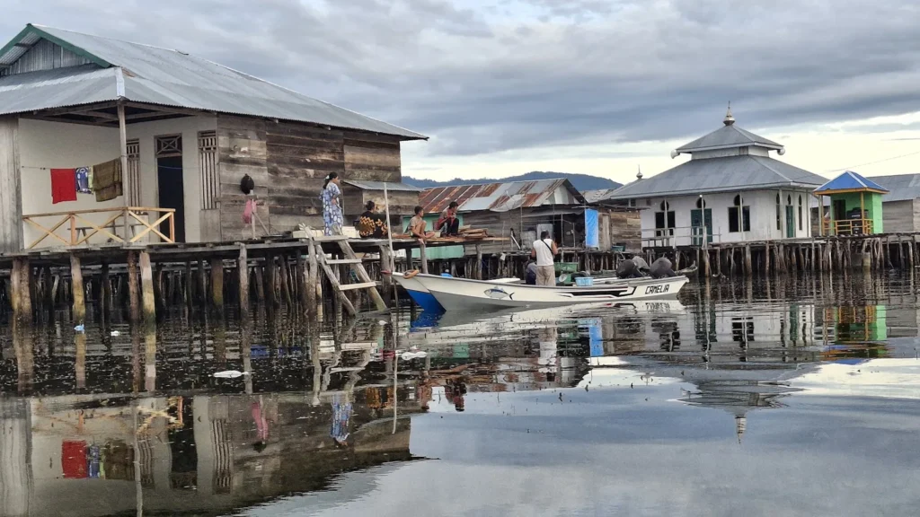 Rumah panggung, perahu, dan warga di kampung Bajo Torosiaje, Gorontalo